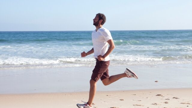浜辺を走り運動する男性